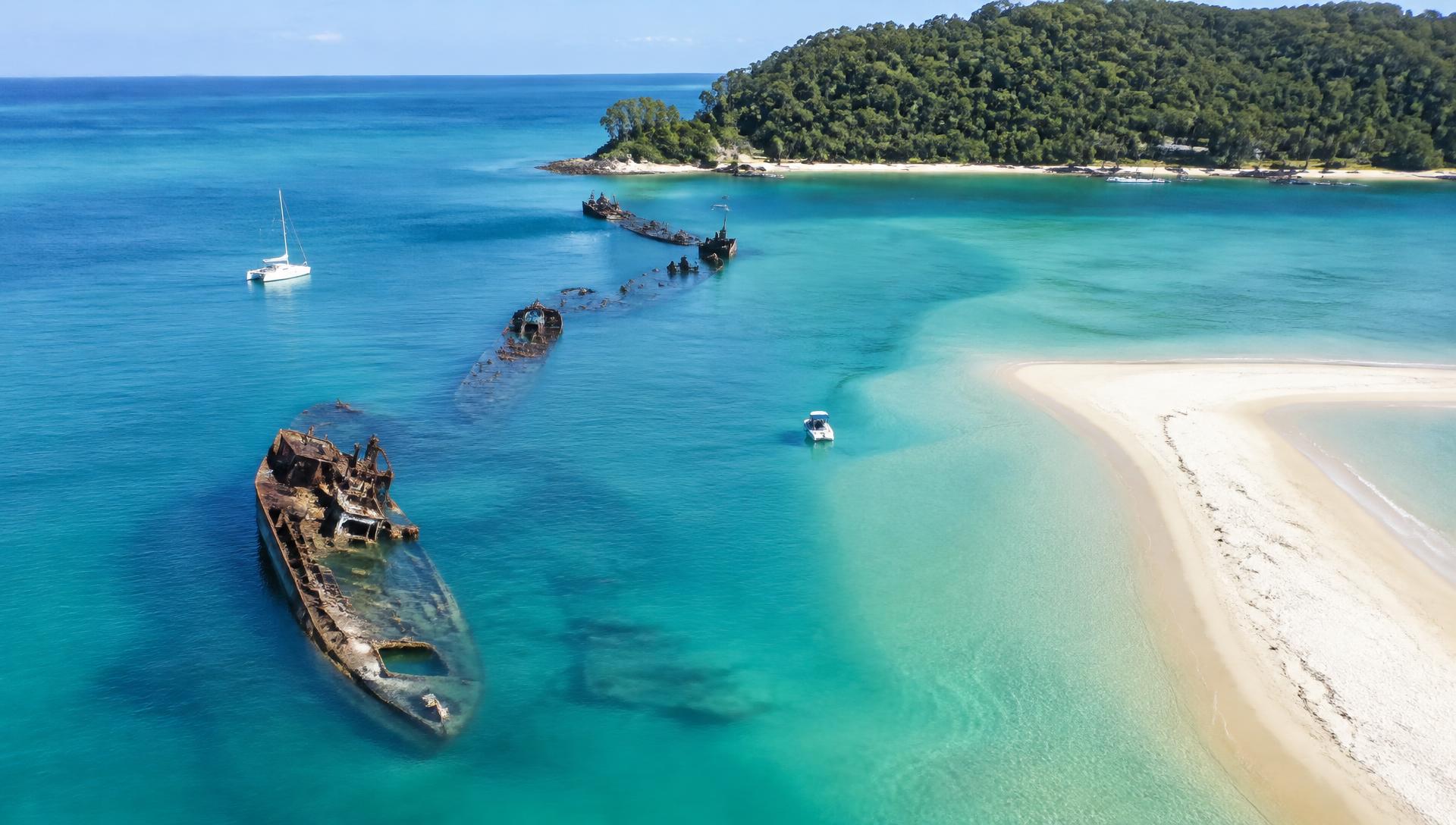 Turquoise bay with half-submerged wrecks and a pale sand spit